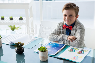 Portrait of businessman sitting at desk in office