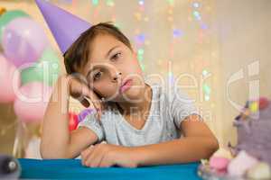 Boy sitting near a birthday cake at home