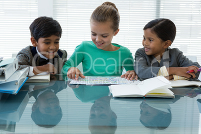 Smiling kids discussing in boardroom
