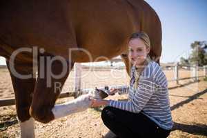 Portrait of female attaching horse shoe