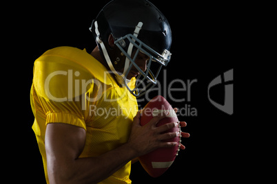 American football player holding a football with both his hands