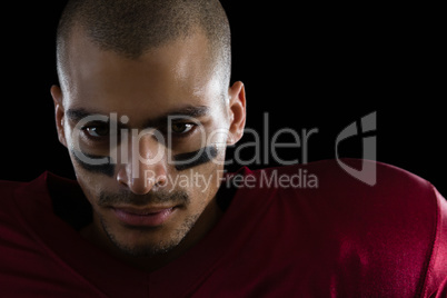 Determined American football player against a black background