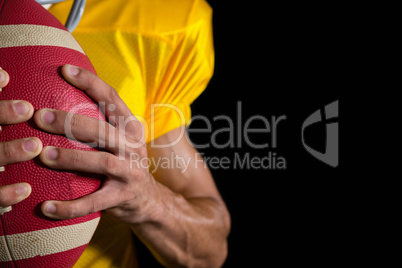 American football player holding a ball with both his hands