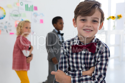 Portrait of businessman standing with colleagues in background at office