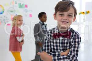 Portrait of businessman standing with colleagues in background at office