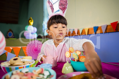 Girl having cookies during birthday party