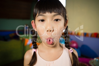 Girl making funny faces during birthday party at home