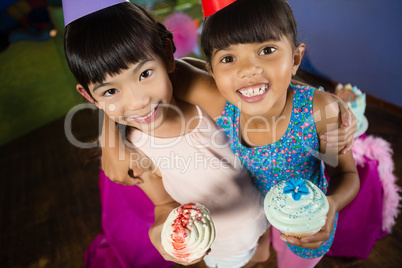 Kids having cupcake during birthday party at home