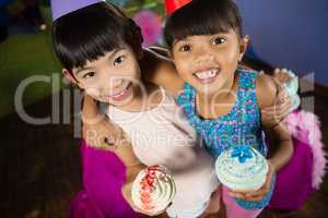 Kids having cupcake during birthday party at home
