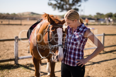 Smiling woman looking at horse
