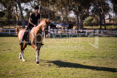 Jockey riding horse at equestrian center