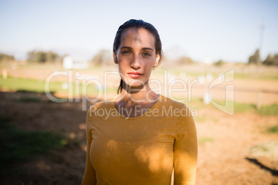 Portrait of serious female jockey standing on field
