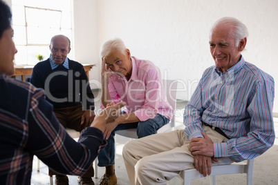 Senior friends discussing in art class