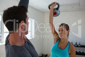 Athletes lifting kettlebells while facing each other in club