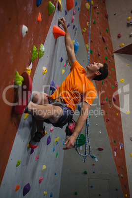 Low angle view of confident man wall climbing