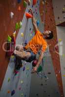 Low angle view of confident man wall climbing