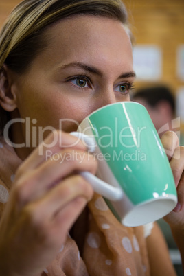 Close up of thoughtful woman drinking coffee at cafe