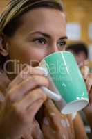 Close up of thoughtful woman drinking coffee at cafe