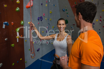 Friends discussing while standing by climbing wall