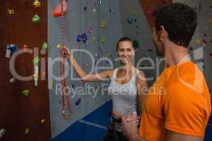 Friends discussing while standing by climbing wall