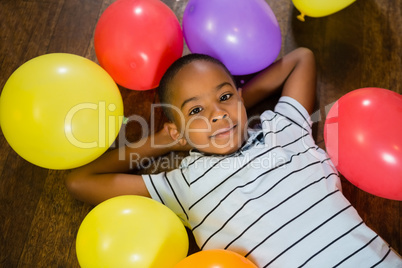 Cute boy relaxing on wooden floor