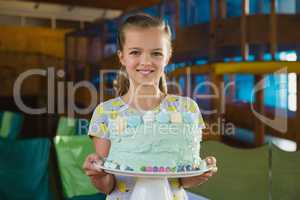 Portrait of smiling girl holding cake