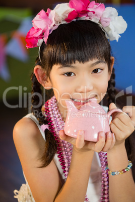 Portrait of cute girl holding toy teapot during birthday party