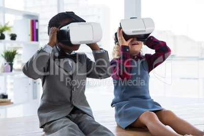 Business people looking through virtual reality simulator while sitting on table