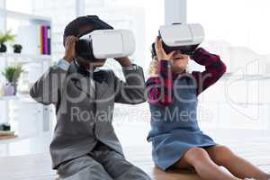 Business people looking through virtual reality simulator while sitting on table