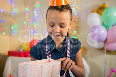 Girl looking at gift bag during birthday party