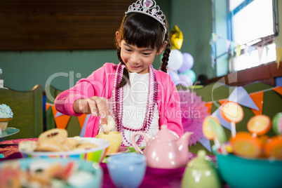 Girl having cookies during birthday party