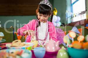 Girl having cookies during birthday party