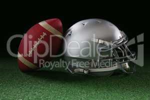 American football leaning on headgear