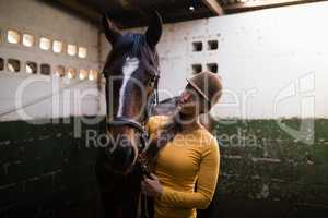 Female jockey looking at horse