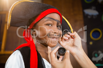 Hand of woman drawing on boy face