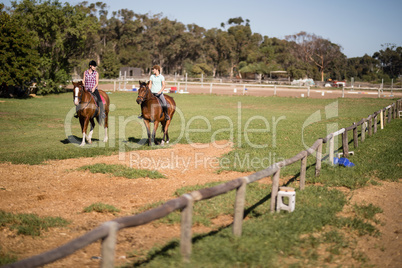 Mid distant view of female friends horseback riding