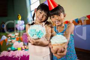 Kids having cupcake during birthday party at home