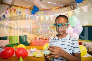 Cute boy decorating cupcake with sparkler during birthday party