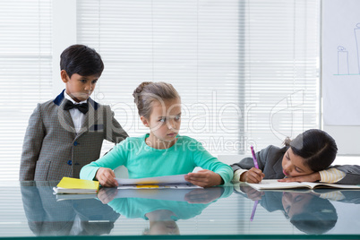 Businessman looking at businesswomen working in boardroom