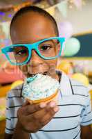 Portrait of cute boy having cupcake during birthday party