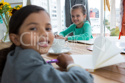 Portrait of smiling businesswoman writing in office