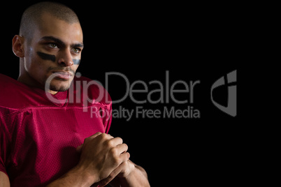 Determined American football player against a black background