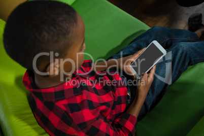 Boy using mobile phone in living room