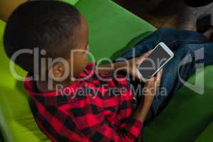 Boy using mobile phone in living room