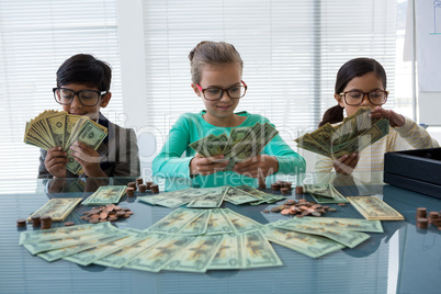 Business people counting money at desk