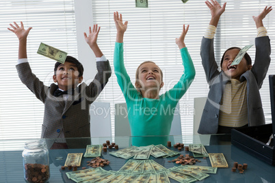 Cheerful business people throwing currency in air