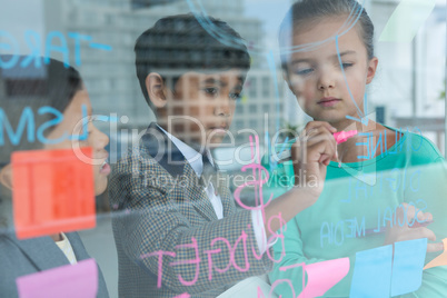 Business people discussing while writing on window seen through glass