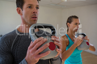 Athletes exercising with kettlebells in club