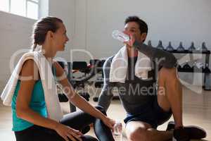 Athletes talking with drinking water in gym