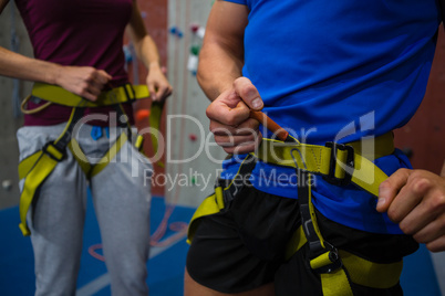 Midsection of athletes adjusting harness